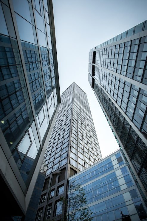vertical-low-angle-shot-high-rise-skyscrapers-glass-facade-frankfurt-germany_181624-7114